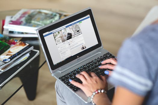 A woman typing on a laptop with social media on the screen, indoors setting.